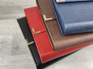 cabrini material document wallets in the colours black, red, brown and navy