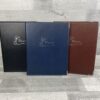 three memories ring binders in colours blue, black and brown with silver blocking reading 'memories' with a lily in the centre front cover of these faux leather folders