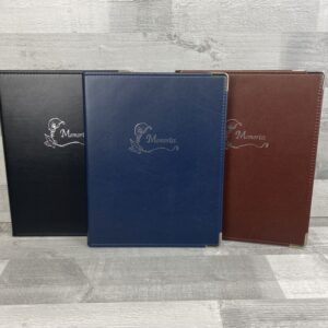 three memories ring binders in colours blue, black and brown with silver blocking reading 'memories' with a lily in the centre front cover of these faux leather folders